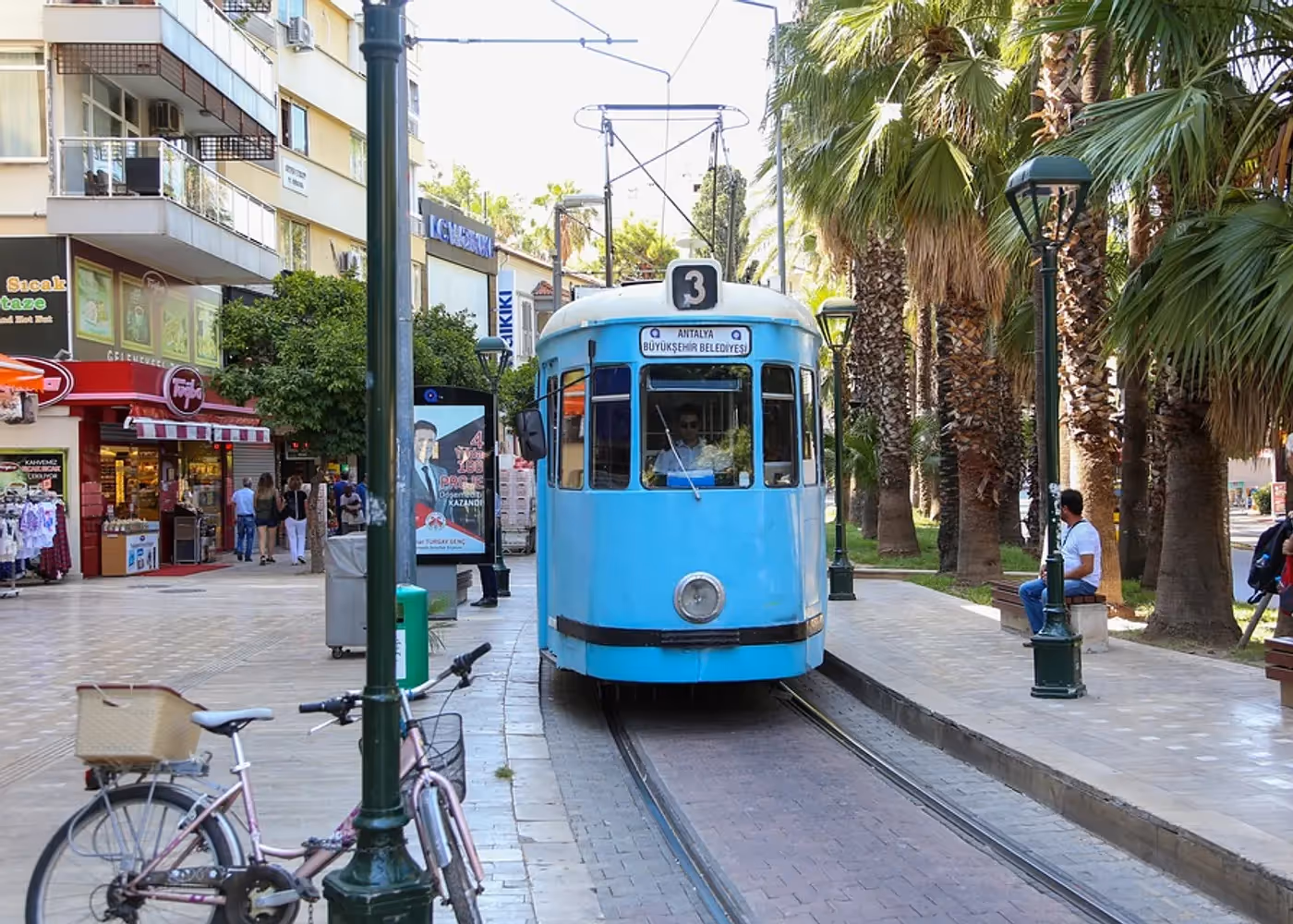 Een nostalgische tram in een straat met palmen in het centrum van Antalya