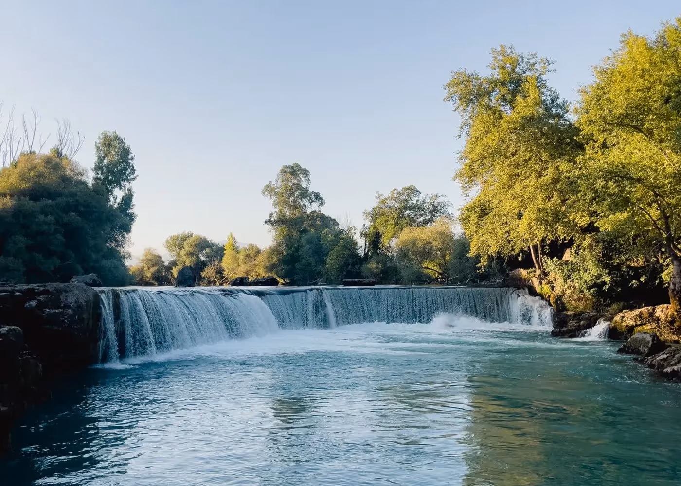 Brede waterval tussen bomen bij Kurşunlu