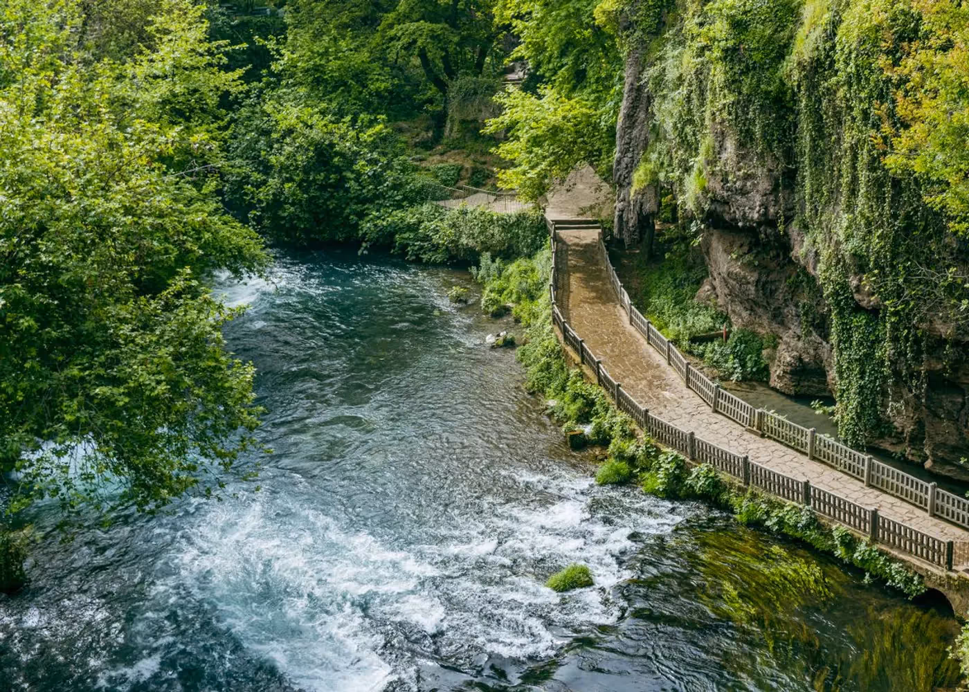 De Düden-rivier stroomt langs een wandelpad met groen bij de bovenste Düden-waterval