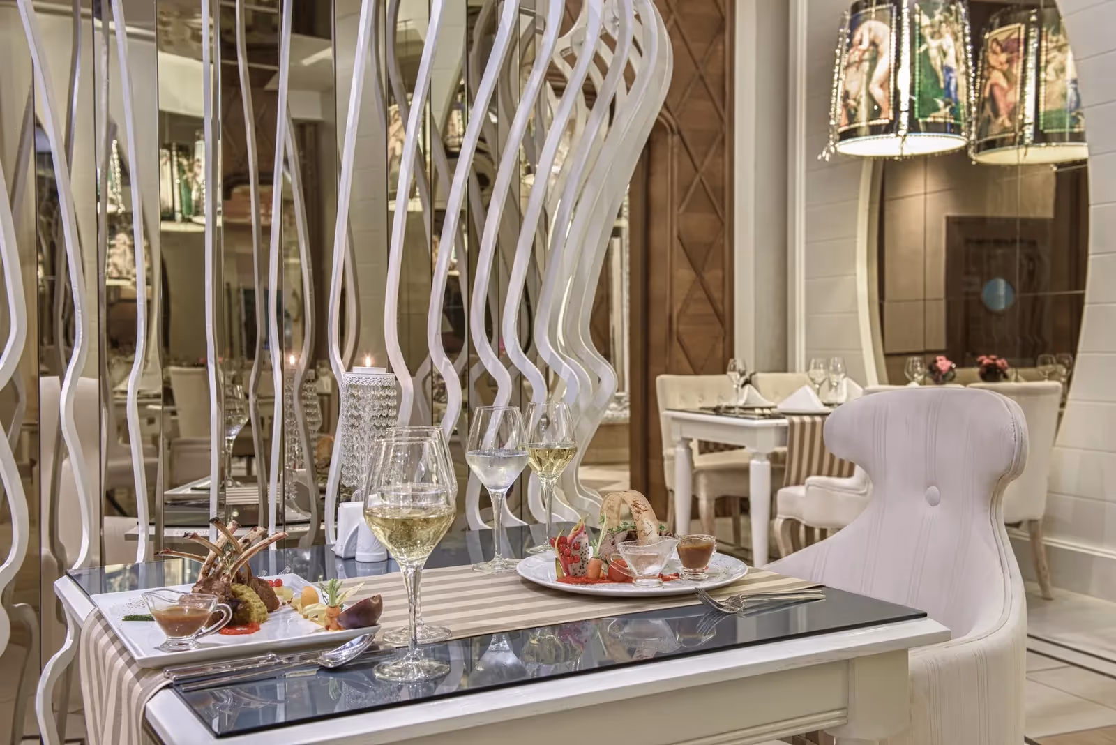 Gedekte tafel met wijnglazen en een uitgeserveerd gerecht in een a-la-carterestaurant van Delphin Imperial in Lara