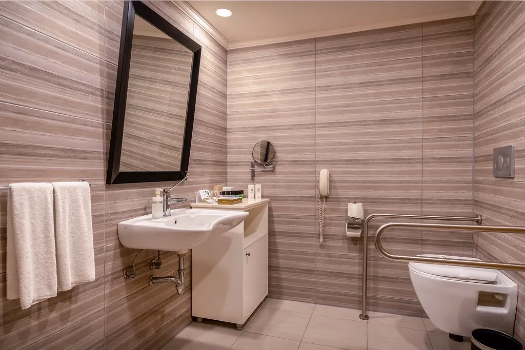 Aangepaste badkamer van Delphin Imperial in Lara met onderrijdbare wastafel, steunbeugels bij het toilet en een telefoon aan de wand