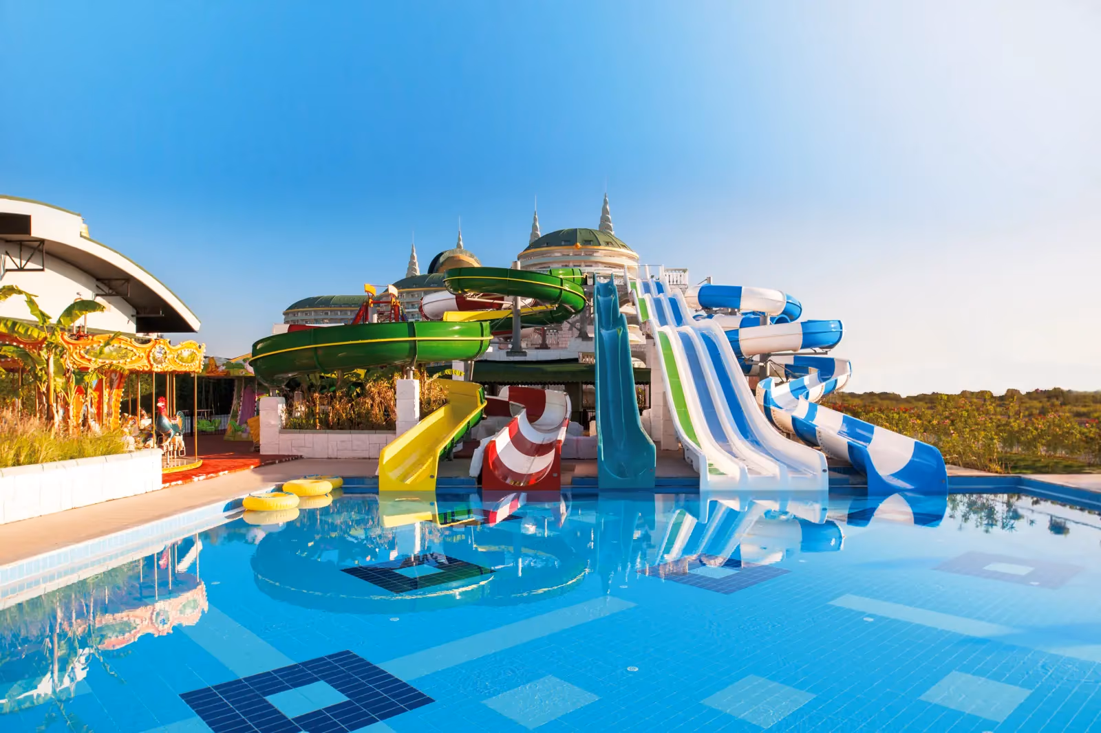Zwembad met een toren vol gekleurde waterglijbanen bij Delphin Imperial in Lara