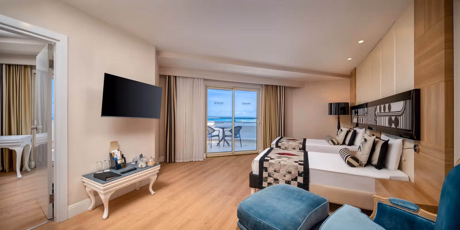 Kamer in Delphin Imperial in Lara met twee bedden, een tv aan de muur, een bijzettafel met glazen en een balkon met zeezicht