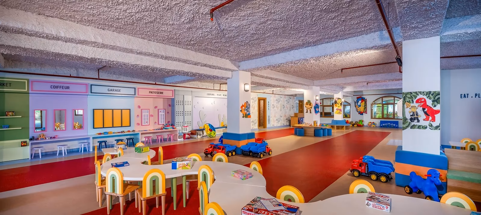Grote speelzaal met tafeltjes en speelgoedauto's in de kinderclub van Delphin Imperial