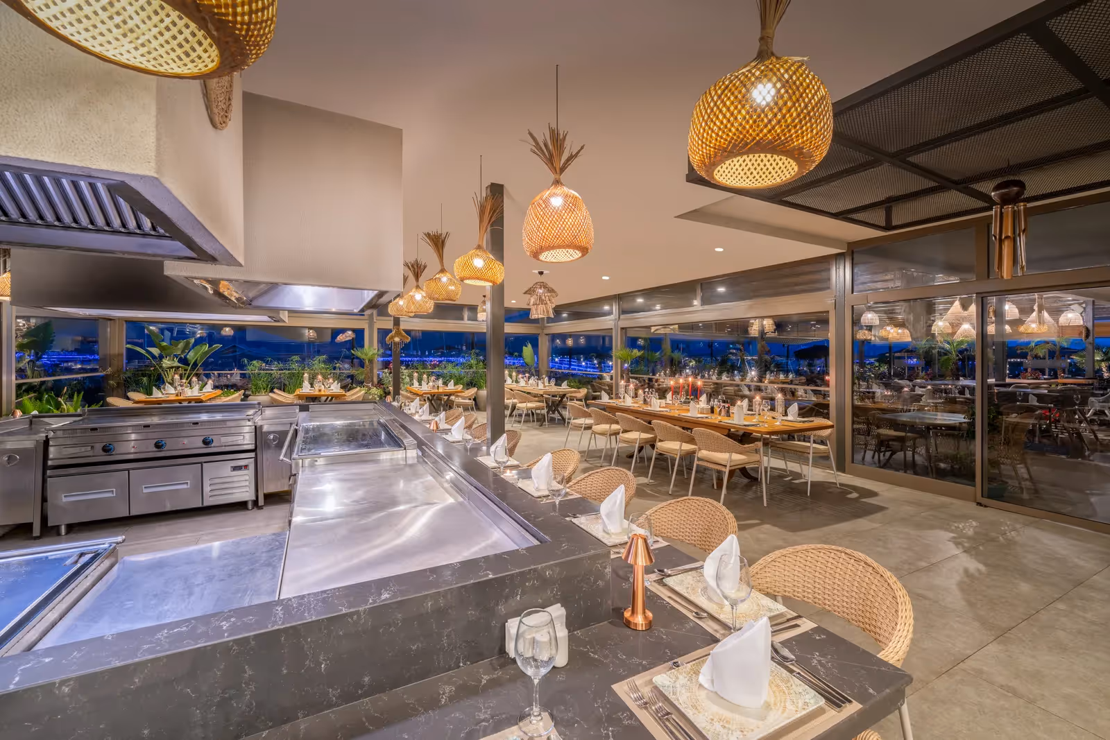 Restaurant Stella Steak van Delphin Imperial met een open grillkeuken, gedekte tafels met rieten stoelen en gevlochten hanglampen