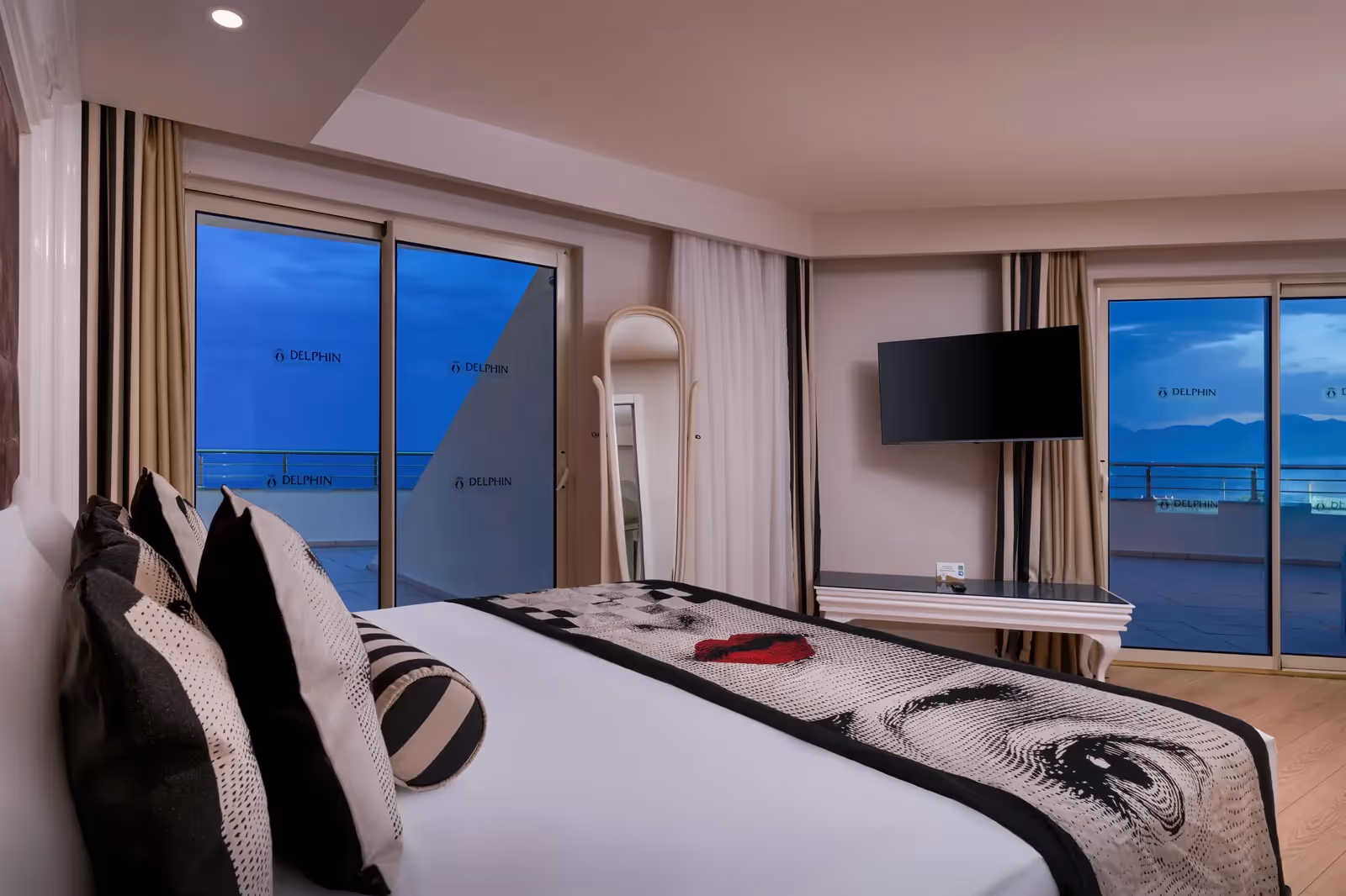 Slaapkamer van de suite in Delphin Imperial met tweepersoonsbed en glazen schuifdeuren naar het terras